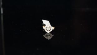 Diamond cluster target ring, set with round brilliant cut diamonds, mounted in white metal on a