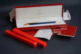 Must de Cartier roller ball, blue lacquer case, gilt hard ware, boxed with full paperwork and