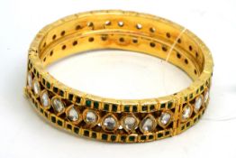 A gem set gold bangle, designed as a row of pear shaped, mixed cut white sapphires to the full hoop,