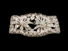 Diamond plaque brooch, designed as two diamond set flowers, in a leaf design border, two central