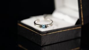 Topaz and diamond ring, central square cut blue topaz, with a small round brilliant cut diamond to