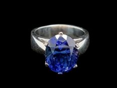 A single stone tanzanite ring, oval cut tanzanite claw set in a heavy white metal mount, ring size