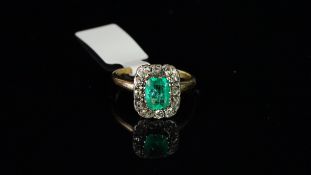 Emerald and diamond cluster ring, central rectangular step cut emerald, surrounded by old cut