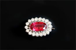 A paste brooch, set with a central oval pink paste stone, surrounded by white paste stones,