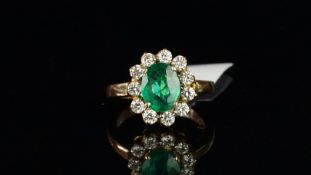 Emerald and diamond cluster ring, central oval cut emerald measuring 10.30 x 7.93 x 4.11mm,