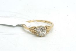 Single stone ring, set with a clear stone, with decorative shoulders, mounted in 9ct yellow gold,