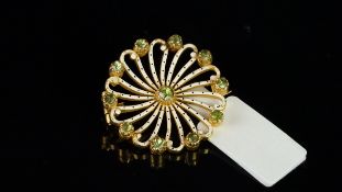 Peridot and white enamel brooch, spiral design with a central peridot and ten further peridot