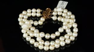 A freshwater pearl, three strand bracelet, 6mm white pearls, with pinkish overtones, on a gilt metal