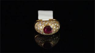 Ruby and diamond bombe ring, central horizontally set oval cut ruby, surrounded by round brilliant