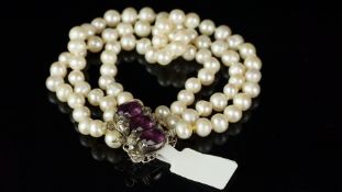 Three strand pearl bracelet, 5.5mm pearls on a white metal clasp stamped 935, set with purple and