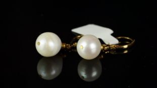 A pair of freshwater pearl earrings, set from a yellow metal hook, stamped 14k