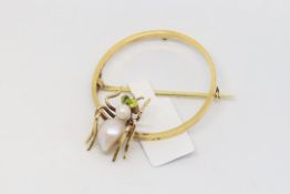 Spider brooch, pearl body, with peridot set eyes, on a yellow metal hoop brooch