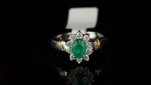 Emerald and diamond cluster ring, oval emerald set in the centre, surrounded by round brilliant