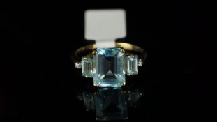 Blue topaz and diamond ring, mounted in hallmarked 9ct yellow gold, central claw set octagonal cut