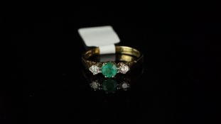 Three stone emerald and diamond ring, mounted in hallmarked 9ct yellow gold, central round