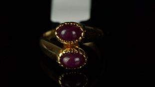 Two stone ruby crossover ring, two oval cabochon ruby stones in a crossover setting, mounted in