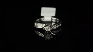 Diamond ring, central brilliant cut diamond claw set with closed back setting, weighing an estimated