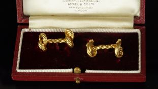 A pair of Asprey & Co. gold knot cufflinks, rope design, with a knot at each end, hallmarked 18ct,