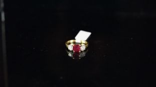 Three stone ruby and diamond ring, central ruby weighing an estimated 1.50ct, with a round brilliant