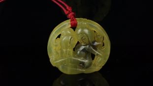 Carved jade pendant depicting two figures, hung on a red cord, diameter 5.5cm, gross weight