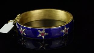 Ruby, diamond and enamel hinged bangle, mounted in unmarked brushed yellow metal, blue enamel with