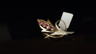 Diamond and ruby floral design brooch in hallmarked 9ct yellow gold, with four claw set rubies,