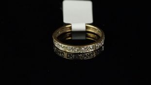 Diamond eternity ring, small diamonds spaced evenly throughout the full hoop, with cut metal detail,