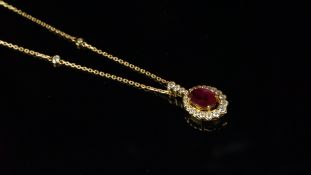 Ruby and diamond cluster pendant, oval cut ruby, surrounded by graduating round brilliant cut