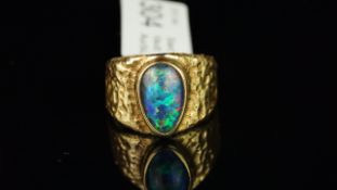 An opal triplet dress ring, with a rub over set pear cabochon opal triplet, measuring