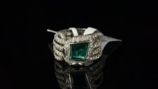 Emerald and diamond coiled snake ring, central kite-shaped emerald in a rub-over setting with two