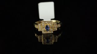 Sapphire and diamond rectangular cluster ring, set with a central oval blue sapphire and