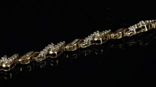A diamond bracelet, alternating links of baguette cut diamonds in a twist link and round brilliant