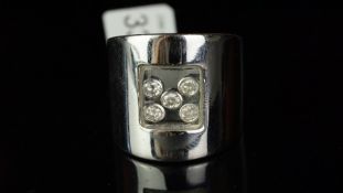 Floating diamond ring mounted in white metal stamped 750, central glass compartment with five rub-