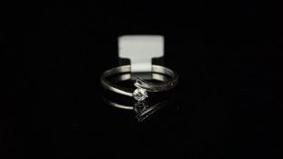 Single stone diamond crossover ring, diamond weighing an estimated 0.11ct, mounted in white metal