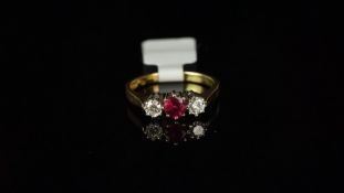 Three stone ruby and diamond ring, claw set, mounted in hallmarked 18ct yellow gold with white