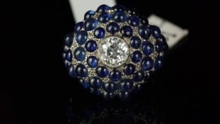 Sapphire and diamond bombe ring mounted in unmarked white metal, set with forty-eight blue