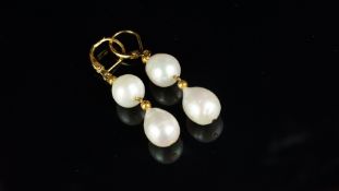 A pair of freshwater pearl earrings, two pearls set from a yellow metal hook, stamped 14k