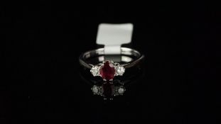 Three stone ruby and diamond ring, central oval ruby claw set with a brilliant cut diamond set to