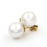 A pair of freshwater cultured pearl stud earrings. The white, cultured pearls 18kt yellow gold