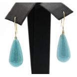 A pair of turquoise set ear pendants. The pear shaped turquoise drop suspended from wire hook