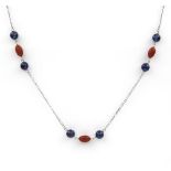 A coral and sapphire bead necklace. The three oval coral beads spaced between pairs of spherical