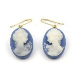 A pair of cameo earrings. Each oval cameo depicting a Neo-Classical woman in profile, to wire hook