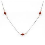 A coral and cultured pearl set necklace. The three oval coral beads set between freshwater