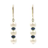 A pair of Akoya cultured pearl and sapphire set earrings. Each earring designed as a line of