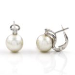 A pair of diamond and South Sea cultured pearl earrings. The cultured pearl set below a claw set