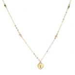 An 18kt yellow gold pendant necklace. The trace link chain set with two circular cut emeralds and