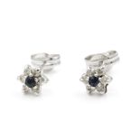 A pair of sapphire and diamond cluster earrings. Each stud earring centred with a claw set round cut