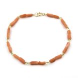 A coral bead bracelet. The irregularly shaped coral beads, to a spring ring clasp, 18kt yellow