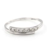 A diamond set ring. The ring designed as a tapered crossover band, set to the front with a row of