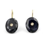 A pair of sapphire and diamond set earrings. The oval cut blue sapphires inset to the centre with